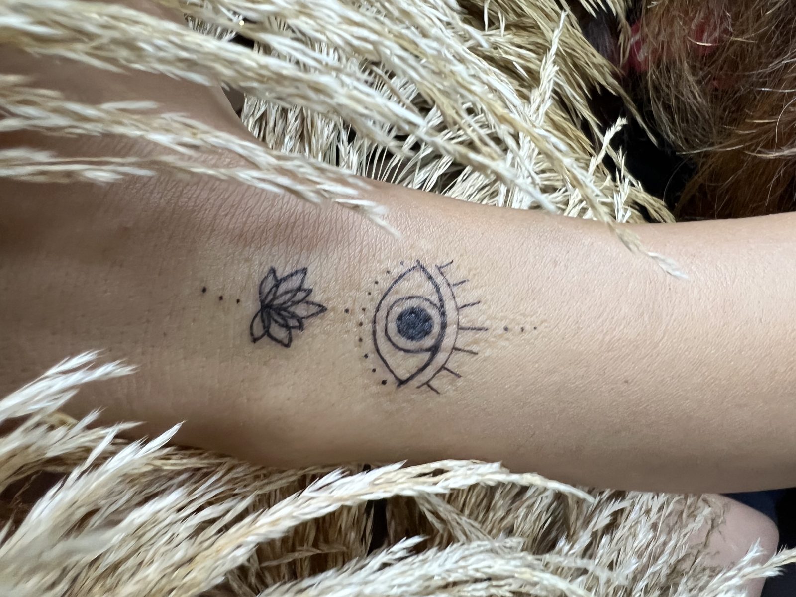 Mini tattoo — lotus and eye design on the forearm